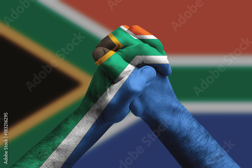 Clasped hands patterned with the South africa flag, multi purpose concept - isolated on flag background