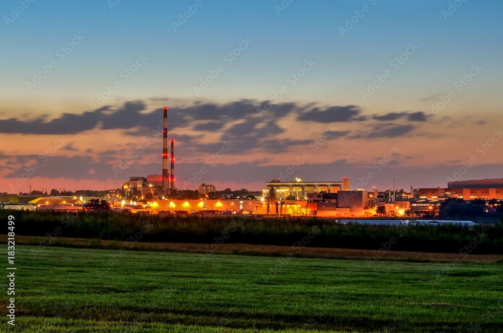 Night industrial landscape. Glowing factories in the city.