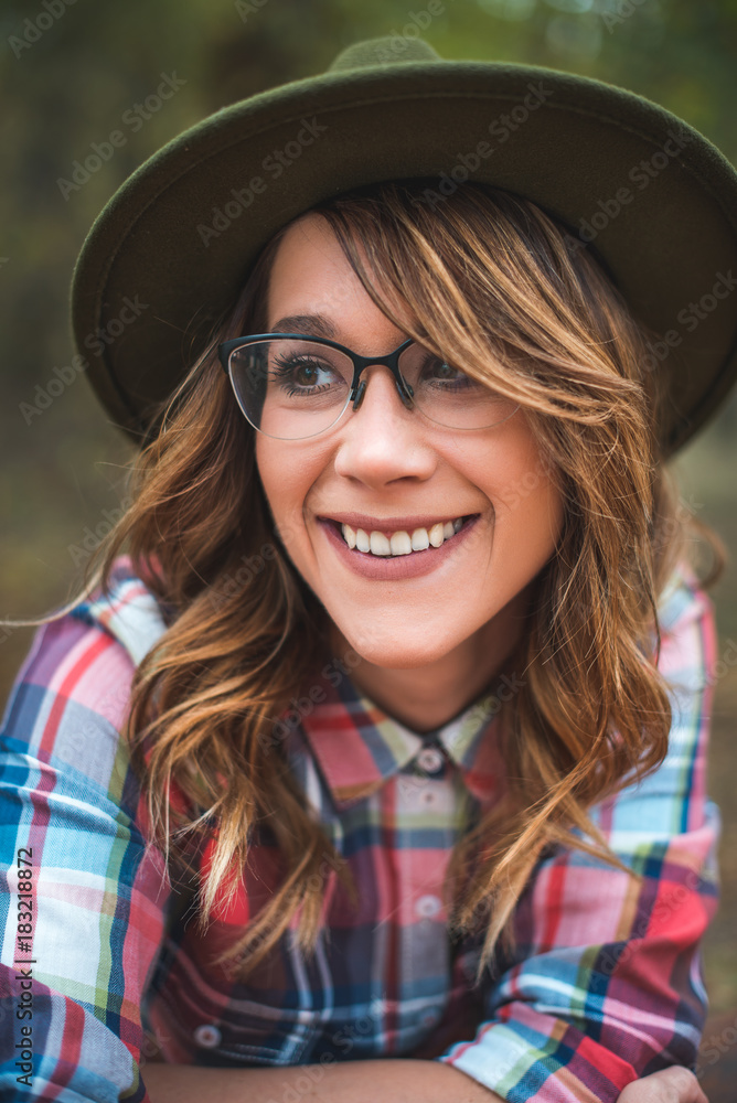Pretty girl with glasses and hat closeup portrait outdoors in the green park in autumn Pretty girl with glasses and hat closeup portrait outdoors in the green park in autumn