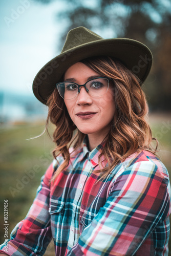  Pretty girl with glasses and hat closeup portrait outdoors in the green park in autumn