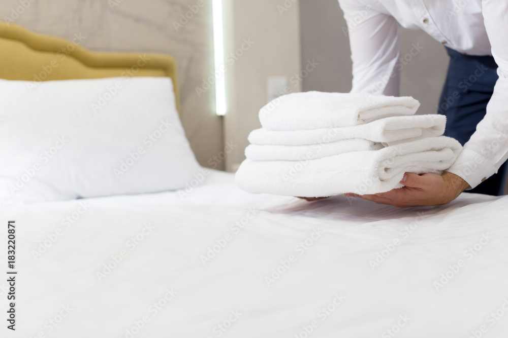hotel staff setting up pillow on bed hotel staff setting up pillow on bed