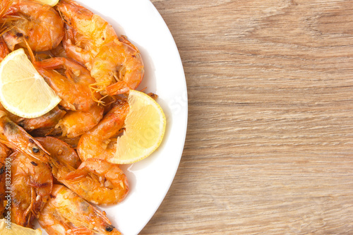 Fried shrimps with lemon. Shrimp fried in a frying pan with butter and garlic.