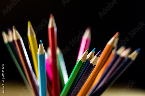 Beautiful and colorful pencil crayons. Bright wooden table.
