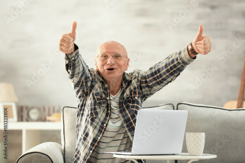 Senior man with laptop at home
