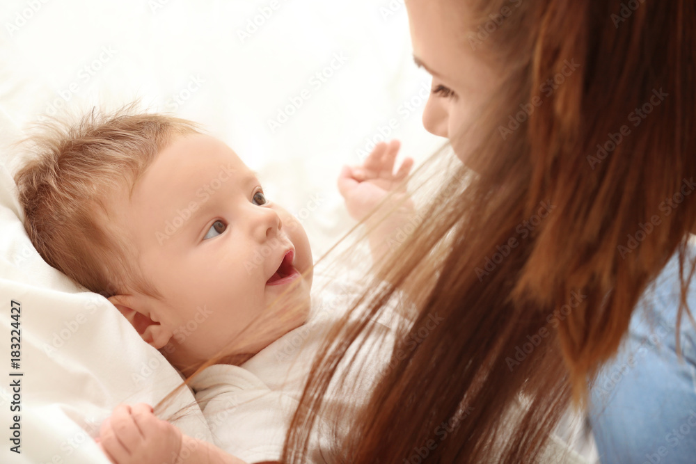 Young mother and cute baby on bed at home Young mother and cute baby on bed at home
