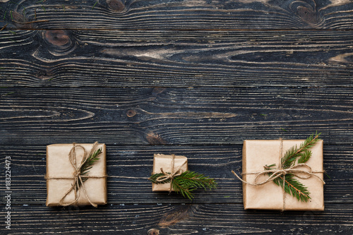 Three Vintage gift boxes with spruce branches on wooden background with copy space