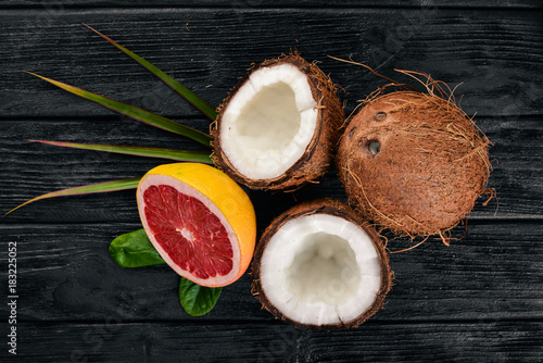 Coconut and grapefruit. Fresh fruits. On a wooden background. Top view. Free space for text.