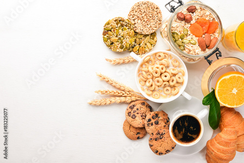 A healthy breakfast. Orange juice, kiwi, croissants, cookies, coffee, on a wooden surface. Top view. Free space for text.