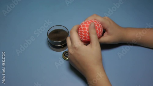 Child bugging in the hands of a soft ball on the blue background. photo