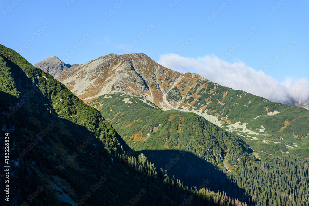 mountain tops in  autumn covered in mist or clouds in sunrise light