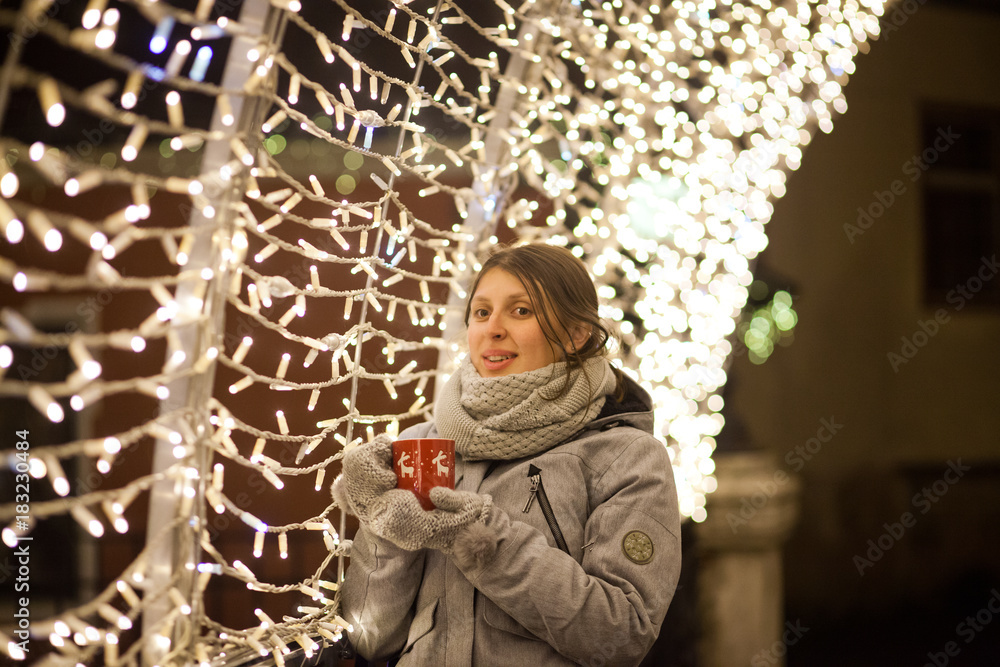 woman holding mug with mulled wine at christmas market woman holding mug with mulled wine at christmas market