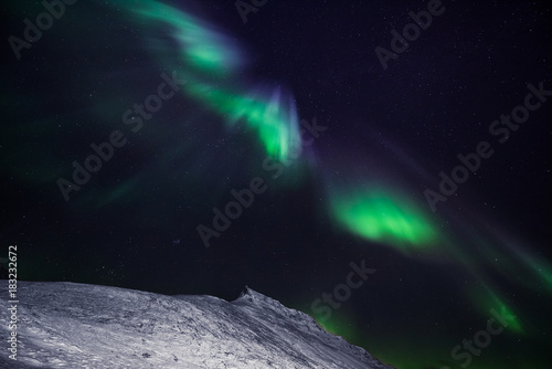 The polar arctic Northern lights aurora borealis sky star in Norway Svalbard in Longyearbyen city the moon mountains