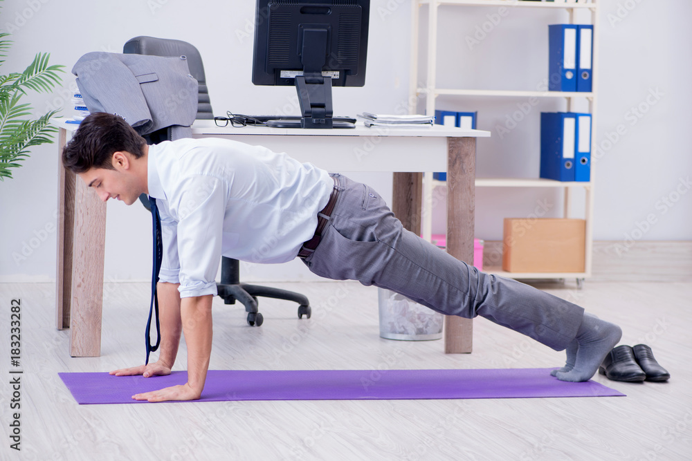 Businessman doing sports in office during break Businessman doing sports in office during break