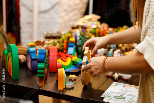 Wooden bright toy in woman hand, handmade christmas market