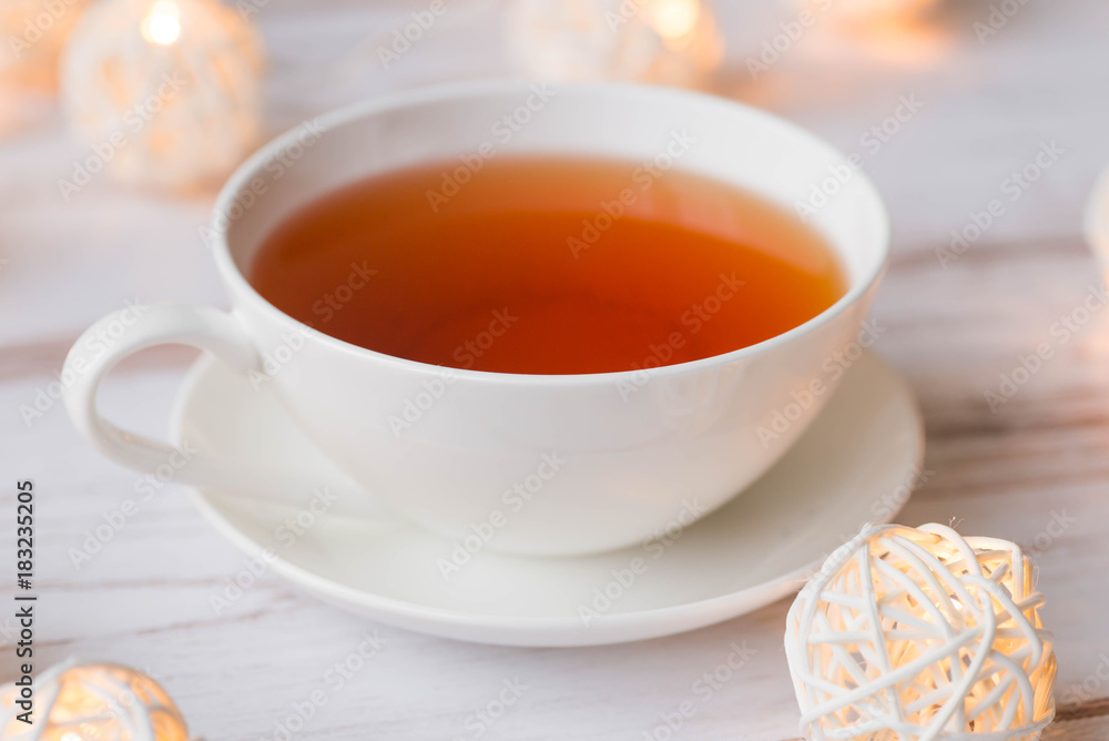 Cup of black tea and Christmas garlands glow Cup of black tea and Christmas garlands glow
