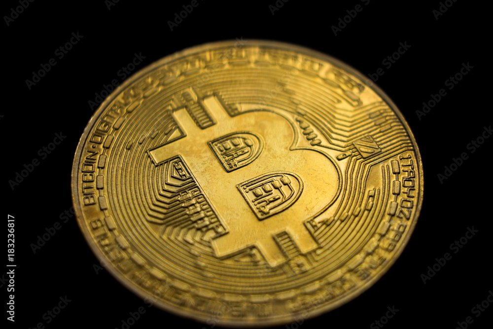 Golden bitcoin (physical), macro shot, isolated on black background Golden bitcoin (physical), macro shot, isolated on black background