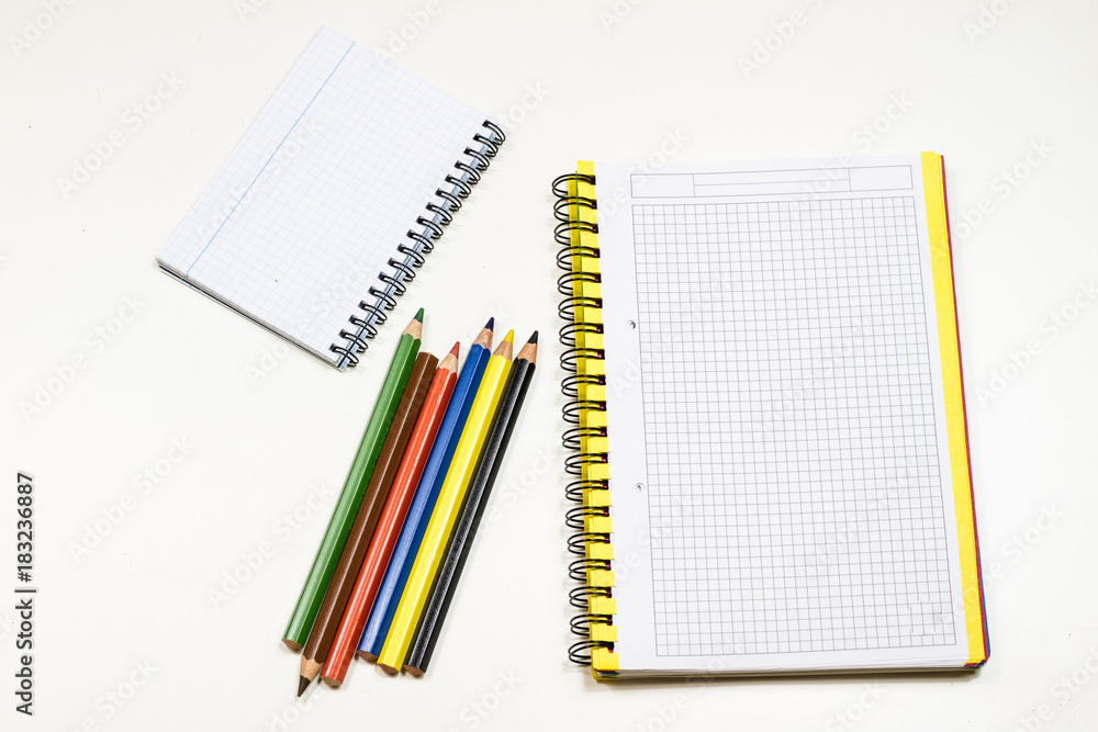 Sensual sketchbook and crayons on a white table. White table and white background. Sensual sketchbook and crayons on a white table. White table and white background.