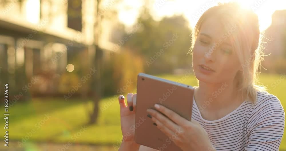 Summer girl portrait, woman holding and using tablet outside. Modern architecture building background Summer girl portrait, woman holding and using tablet outside. Modern architecture building background