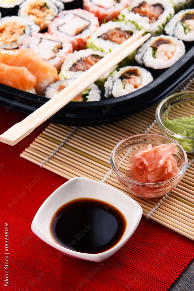 Composition with assorted sushi rolls and bowls of spices