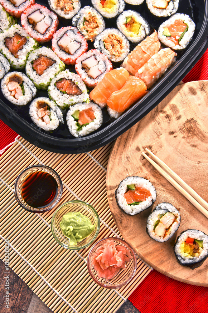 Composition with assorted sushi rolls and bowls of spices
