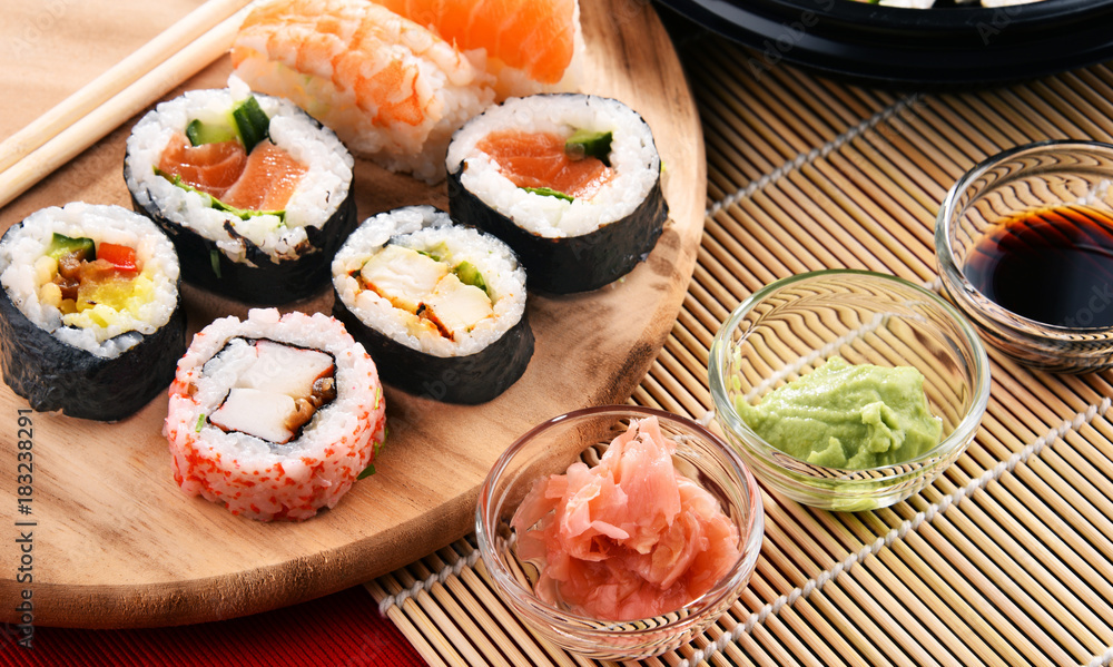Composition with assorted sushi rolls and bowls of spices Composition with assorted sushi rolls and bowls of spices