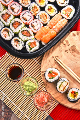 Composition with assorted sushi rolls and bowls of spices