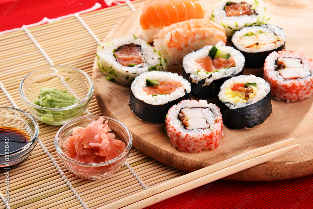 Composition with assorted sushi rolls and bowls of spices Composition with assorted sushi rolls and bowls of spices