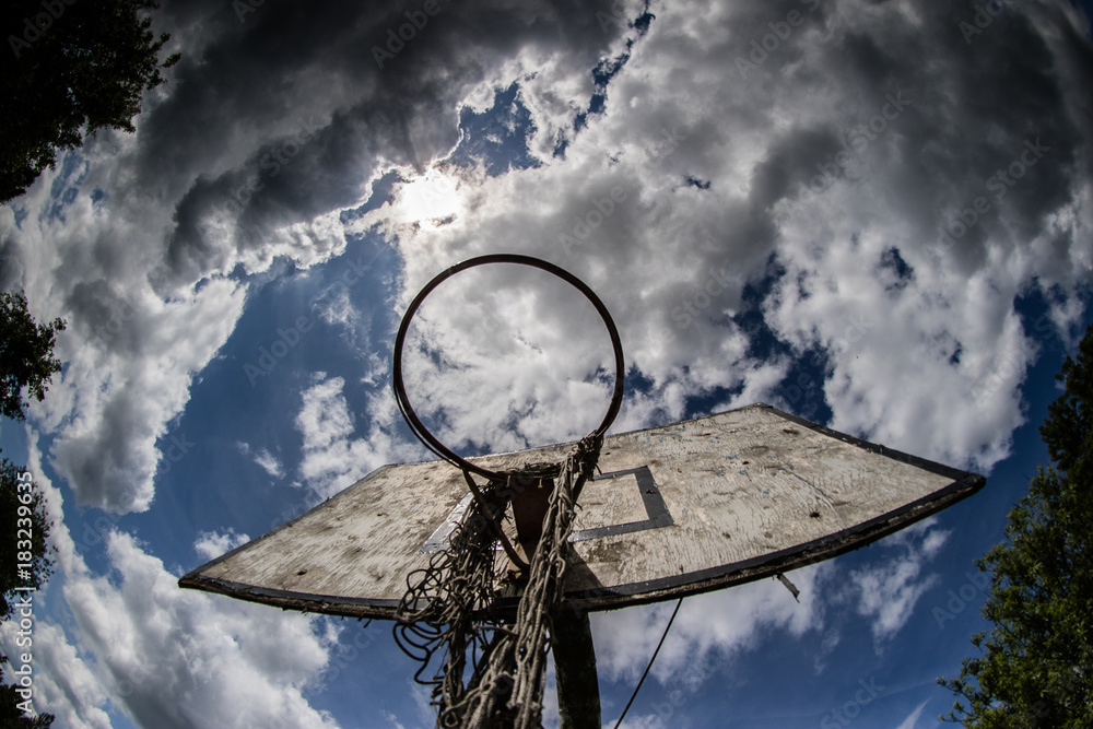 Old basketball court, basket, snatched netting against the sky Old basketball court, basket, snatched netting against the sky