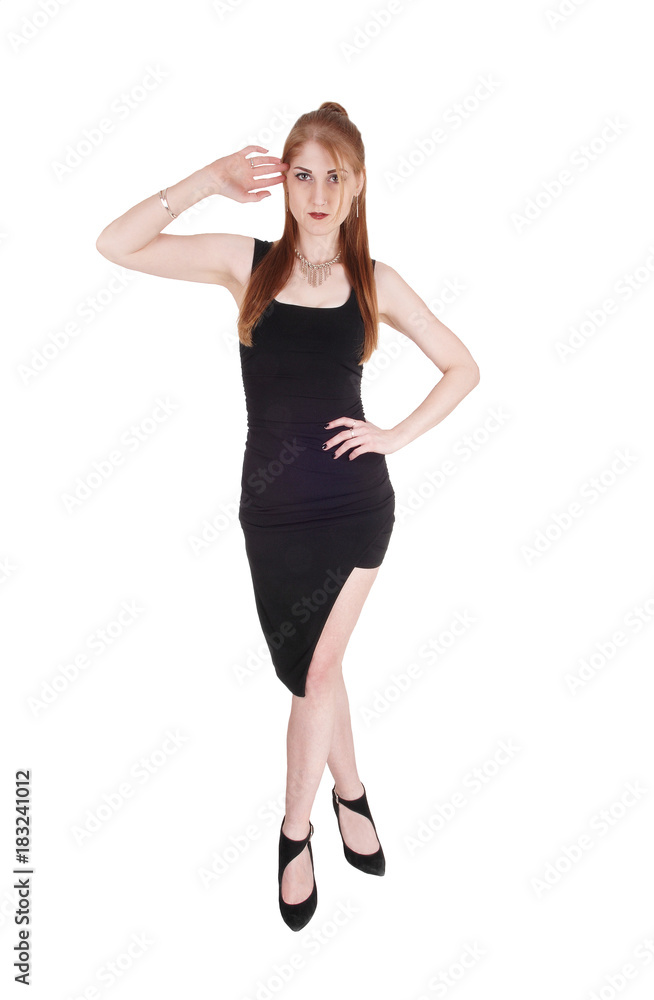 Woman standing in a black dress and heels Woman standing in a black dress and heels