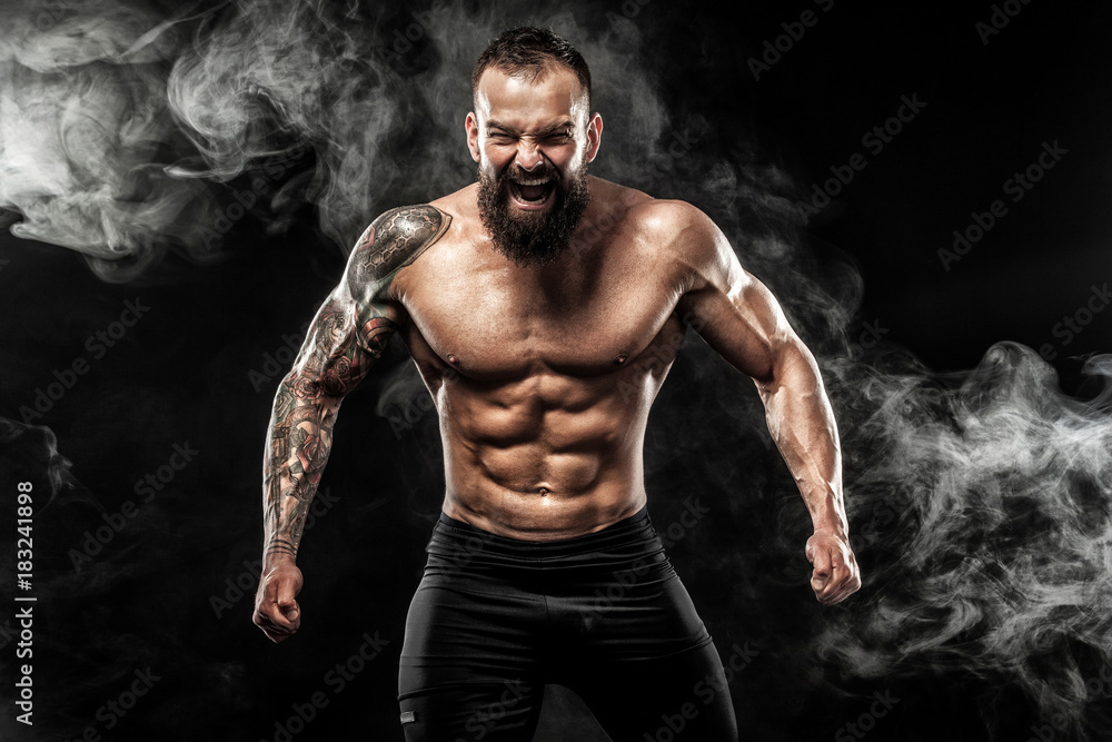 Obraz premium Sportsman muay thai boxer celebrating victory on black background with smoke. Copy Space. Sport concept.