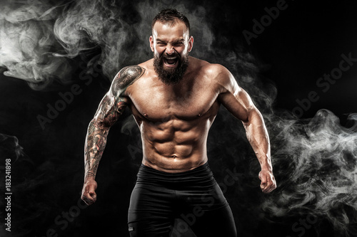 Sportsman muay thai boxer celebrating victory on black background with smoke. Copy Space. Sport concept.