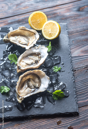 Raw oysters on the black stone board