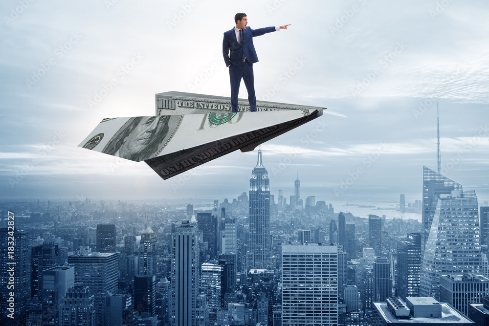 Businessman flying on paper plane in business concept Businessman flying on paper plane in business concept
