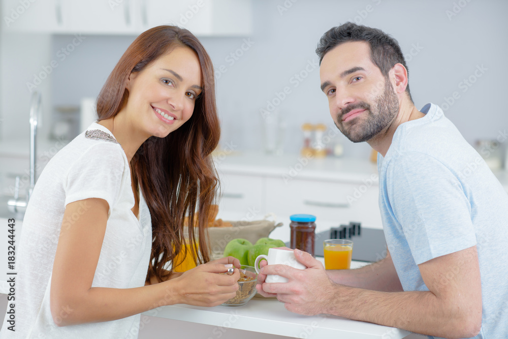 young happy couple having breakfast together with fruits and juice young happy couple having breakfast together with fruits and juice