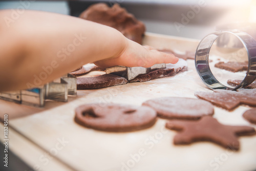 Baking gingerbreads. The family is preparing a gingerbread. The boy is making a gingerbread mold. Preparing for Christmas, time for the family, cooking together and baking the concept. 
