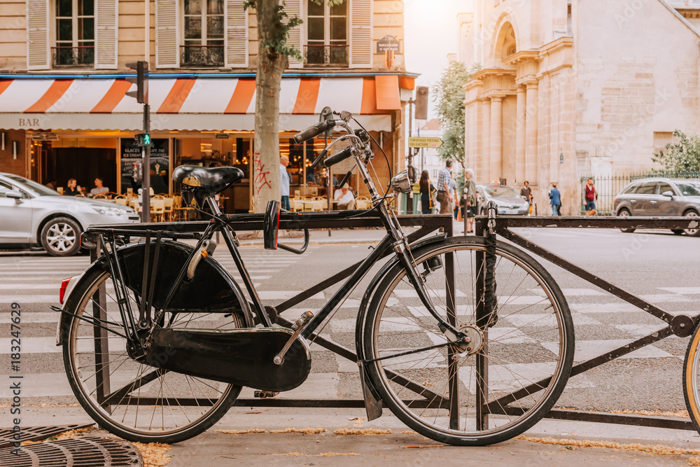 Old bicycle parked on Boulevard Saint-Germain in Paris, France