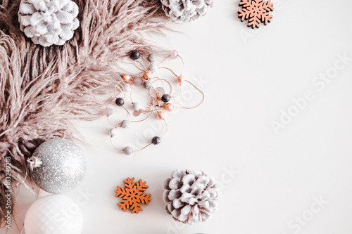 Woman Christmas background on white. Frosty pine cones, silver colored decoration balls, faux fur, jewelry. Copyspace for text, overhead, horizontal © Iuliia
