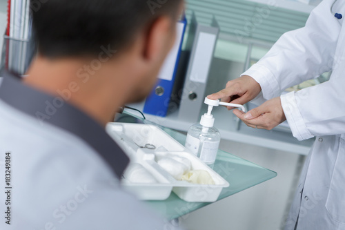 Medical worker dispensing antibacterial gel onto hand