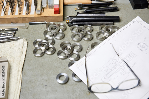 Composition of work tools. Blueprint upon steel washers. photo