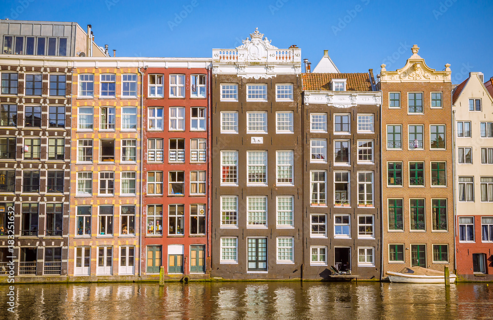 Obraz premium Traditional old buildings and and boats in Amsterdam, Netherlands. Canals of Amsterdam.