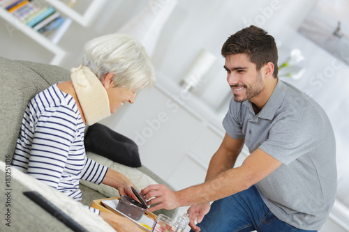 Foto senior woman with cervical collar being assisted at home