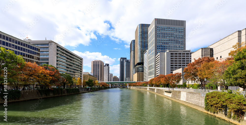 The high office building has an intermediate river in Autumn season at Osaka, Japan