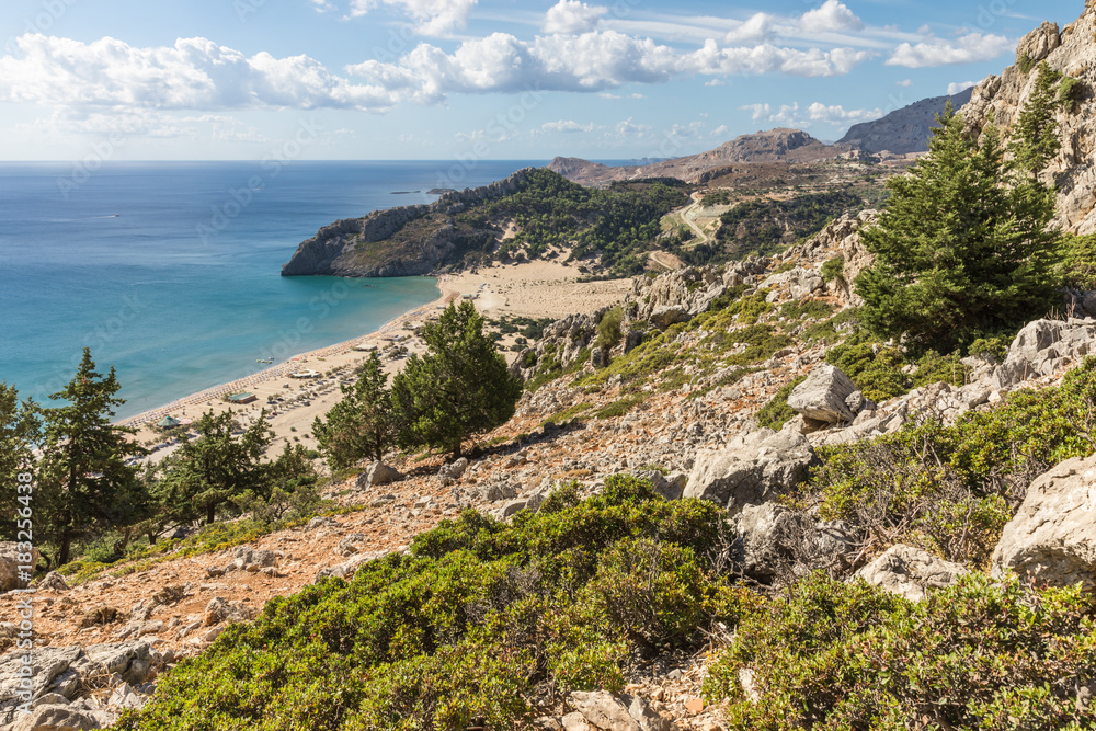 Stony landscape and a view of the Tsambika beach on the Rhodes Island, Greece Stony landscape and a view of the Tsambika beach on the Rhodes Island, Greece