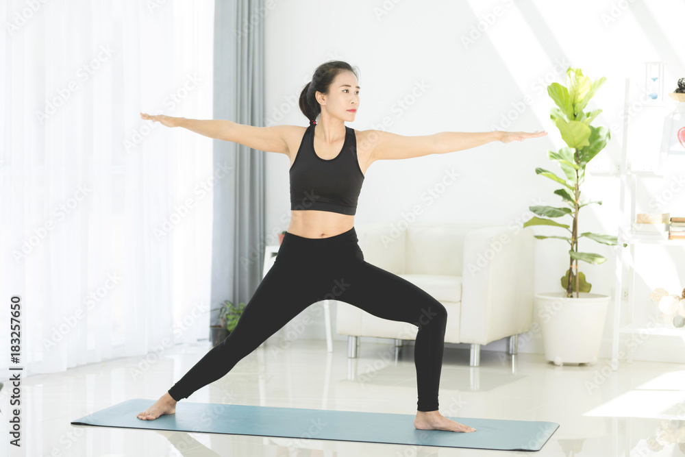 Obraz premium Asian beautiful sports woman performs the exercises at home .