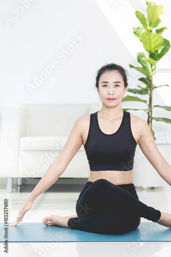Asian beautiful sports woman performs the exercises at home .