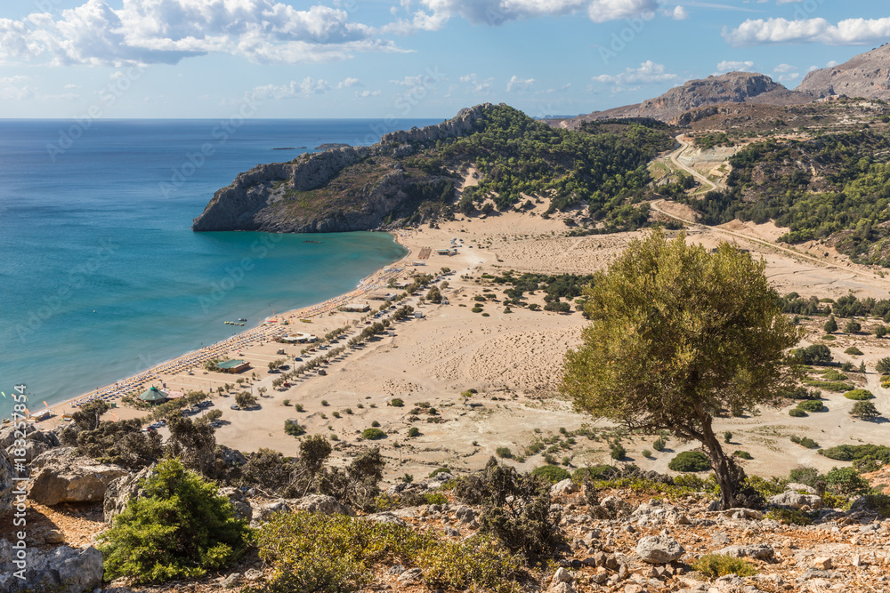 Stony landscape and a view of the Tsambika beach on the Rhodes Island, Greece