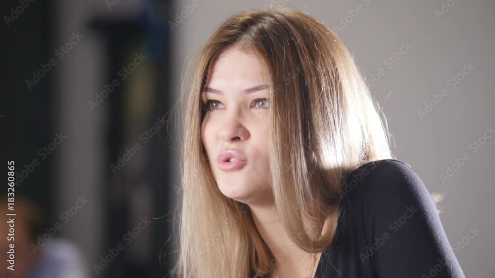 Blonde young woman sitting in cafe with girlfriend