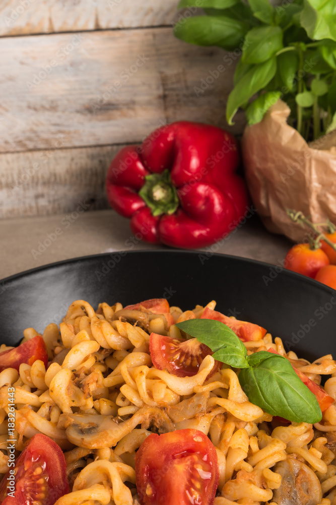 Italian wholemeal pasta with tuna, mushrooms and basil. Fresh pasta with tuna and tomato sauce on old wooden background. Italian wholemeal pasta with tuna, mushrooms and basil. Fresh pasta with tuna and tomato sauce on old wooden background.