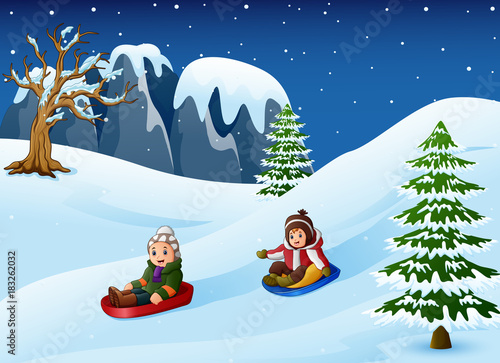 Children sledding in snow downhill 