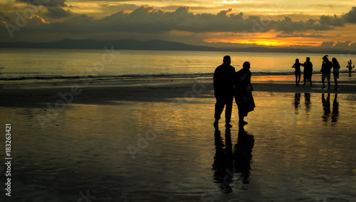 Elderly Couple Walking on a Beach In Sunset